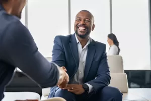 Two happy mature business men shaking hands in office
