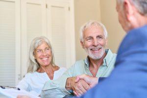 couple is shaking hands with a financial adviser